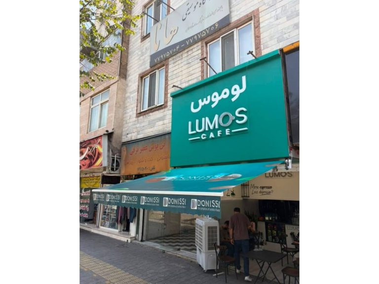 نمای جانبی سایبان بازویی فیروزهای کافه لوموس در کرج با چاپ تبلیغاتی روی پوشش و آویز